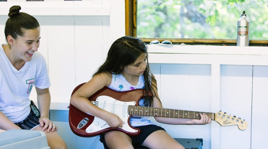 Girl playing guitar indoors