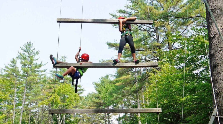 Girls on high ropes course ladder
