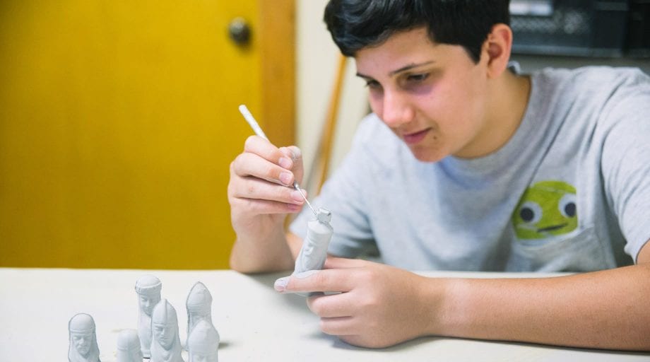 Boys painting ceramic figurines