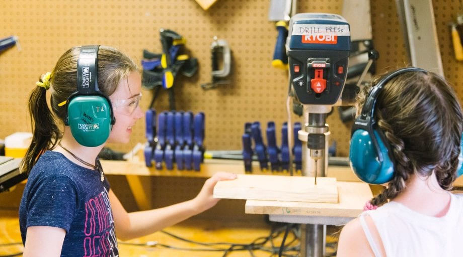 Girls at woodworking with drill