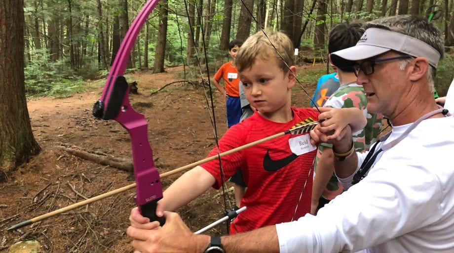 Boy learning archery on Rookie Day