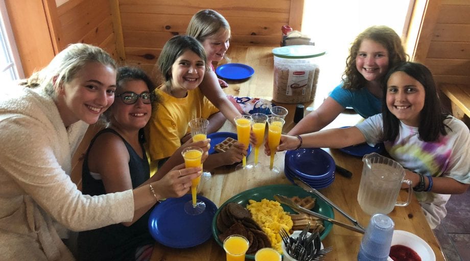 Campers clinking glasses during breakfast