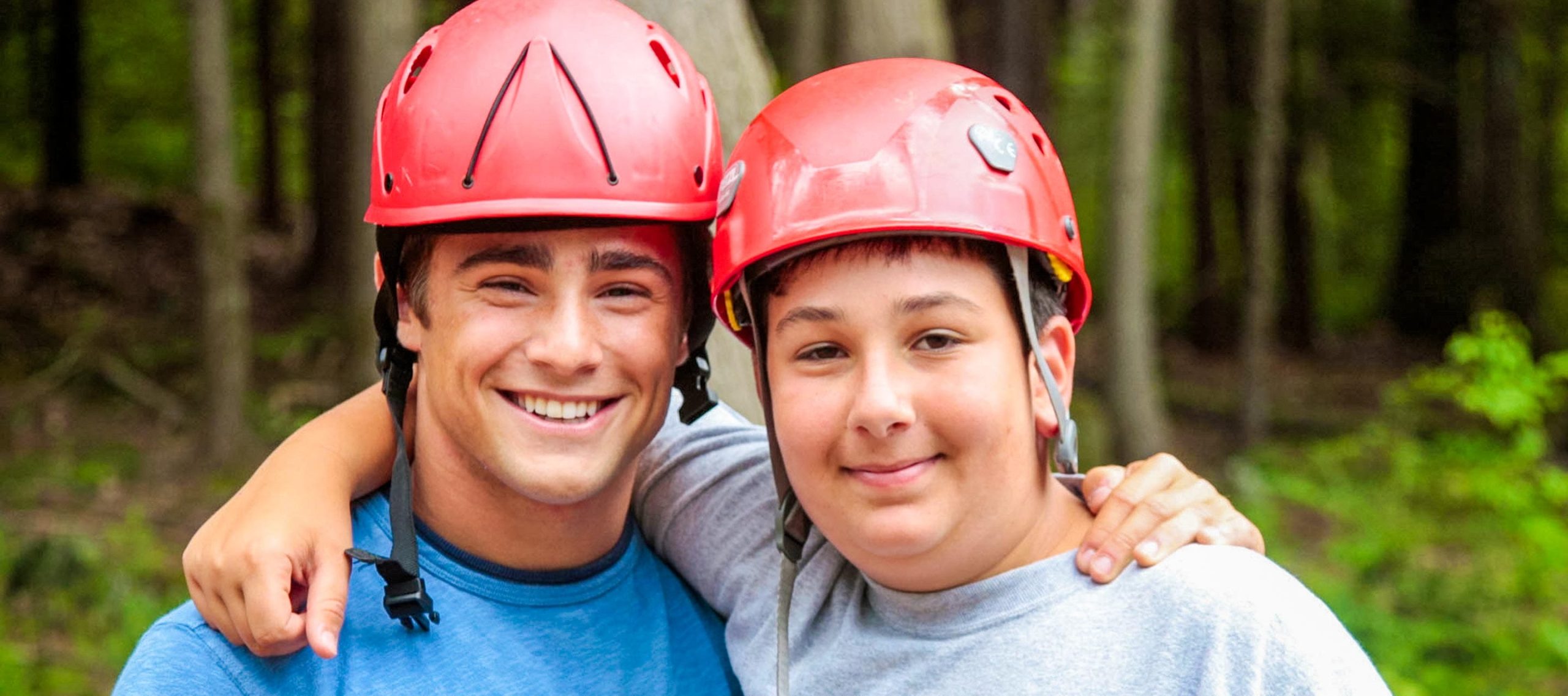 Camper and staff wearing red climbing helmets