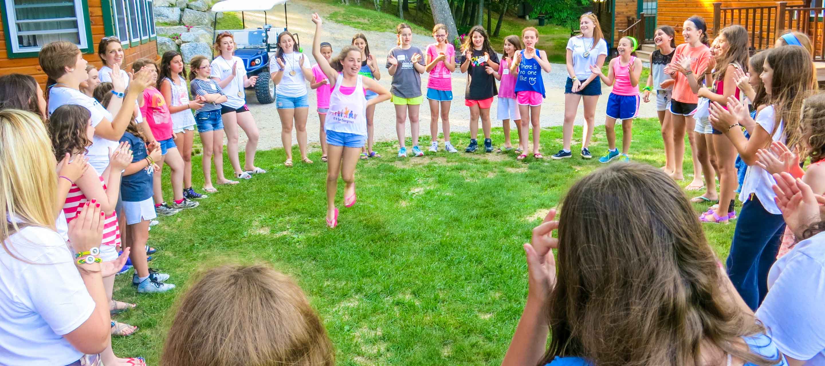 Campers in a circle and a girl dancing in the middle