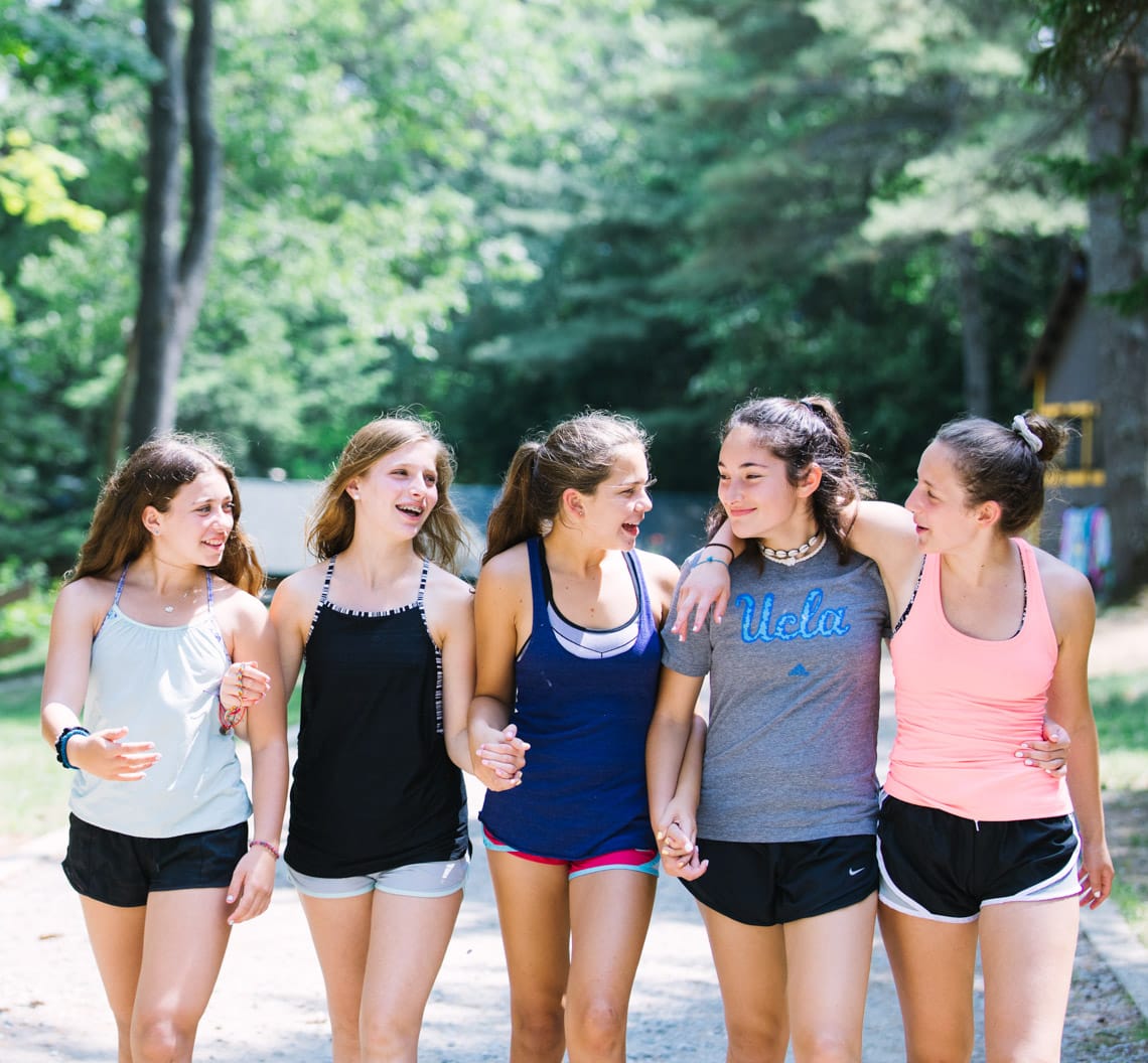 Five older girls walking and holding hands