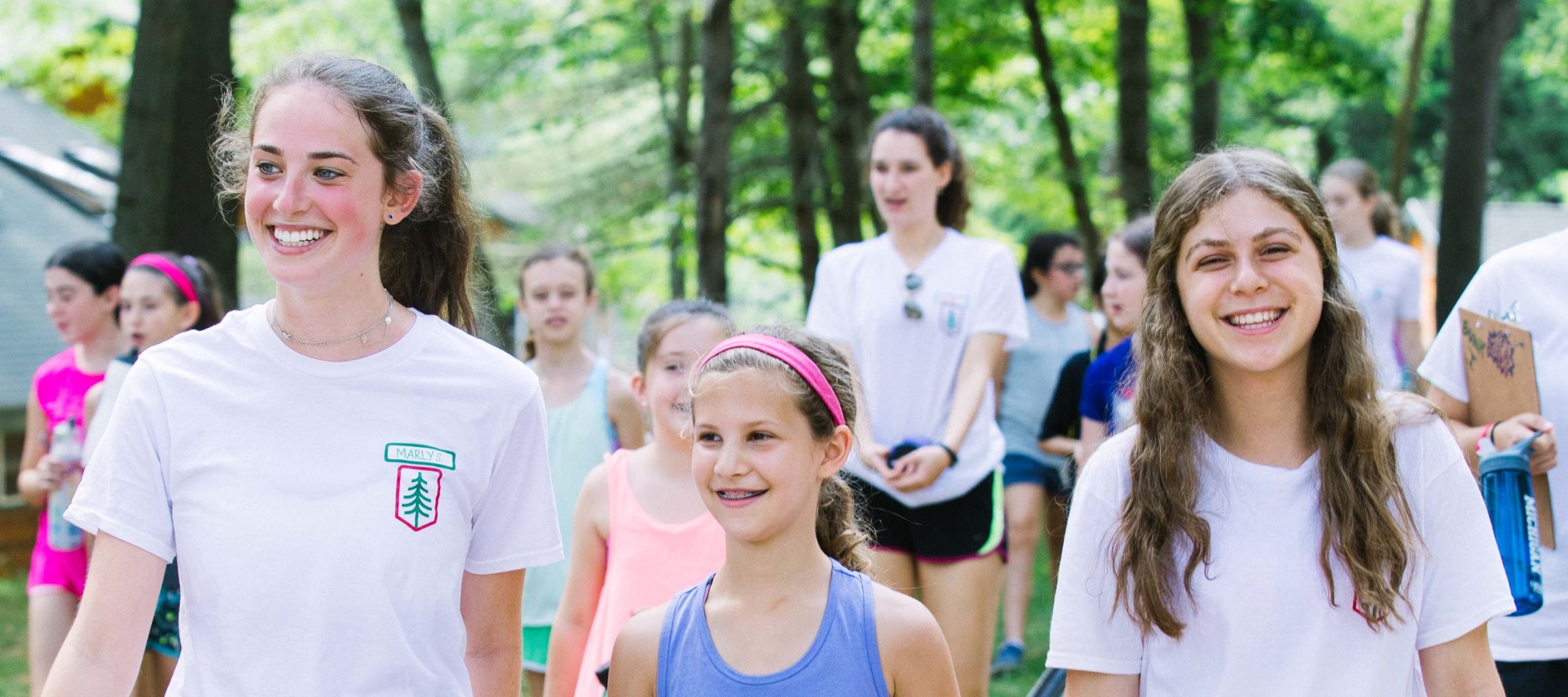 Female staff and campers walking