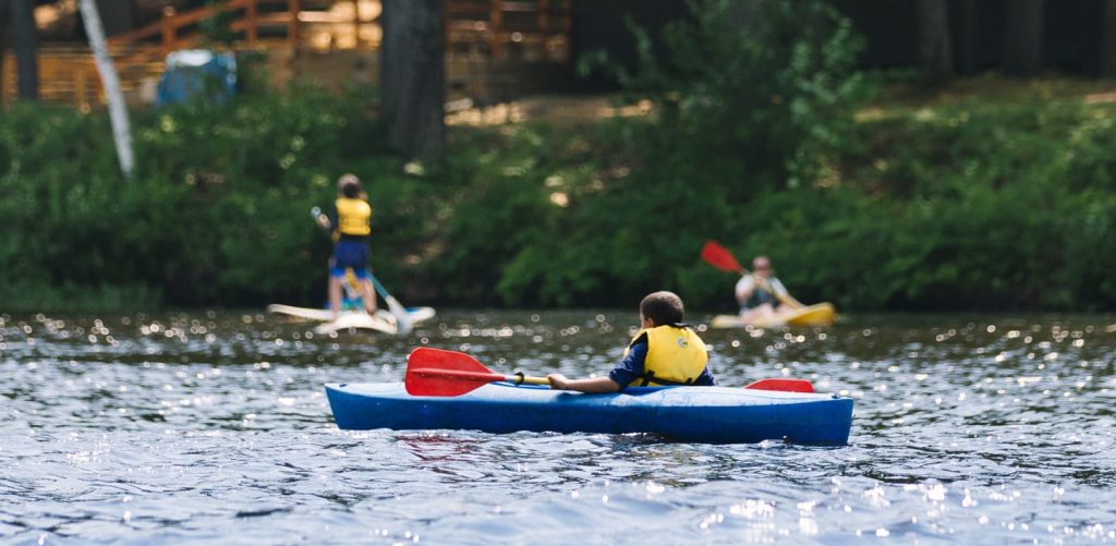 Boy in blue kayak on lake