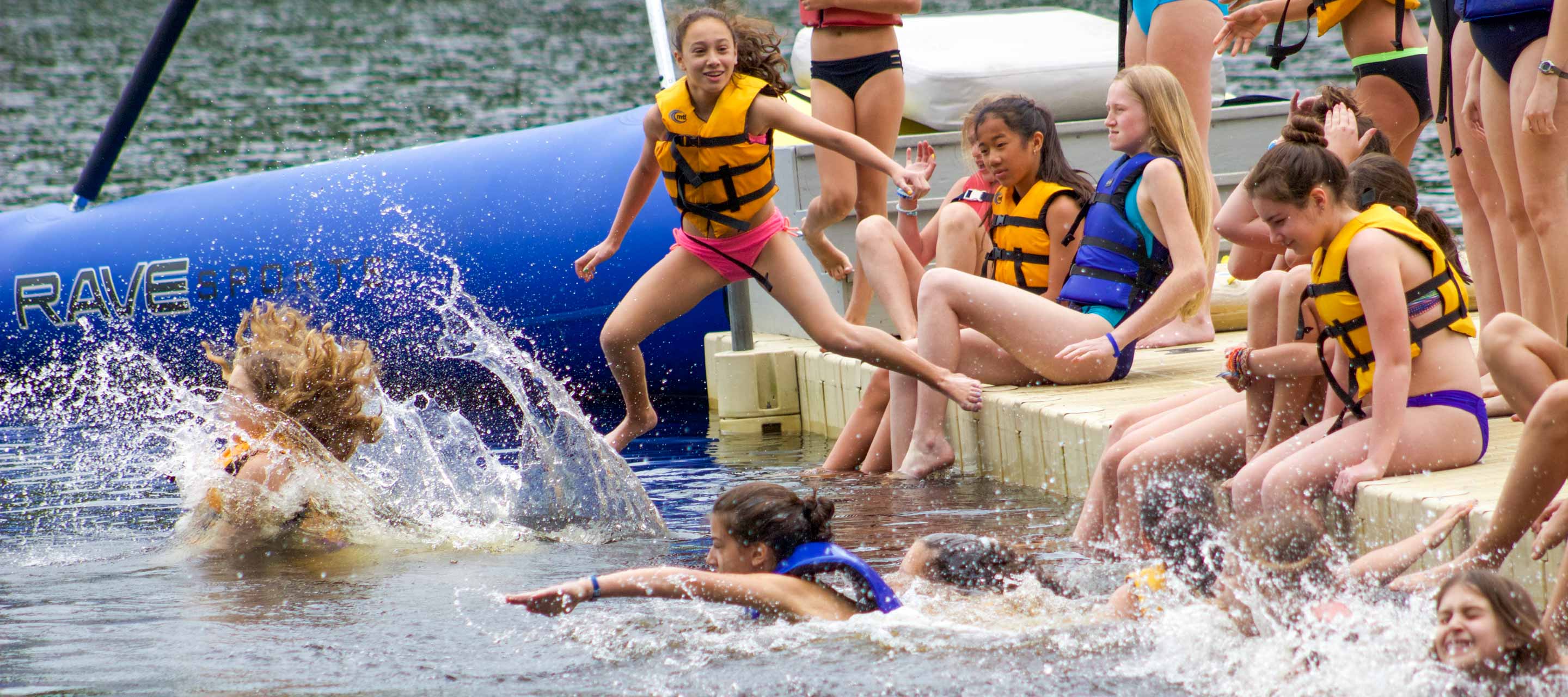 Girls jumping into lake for swim race