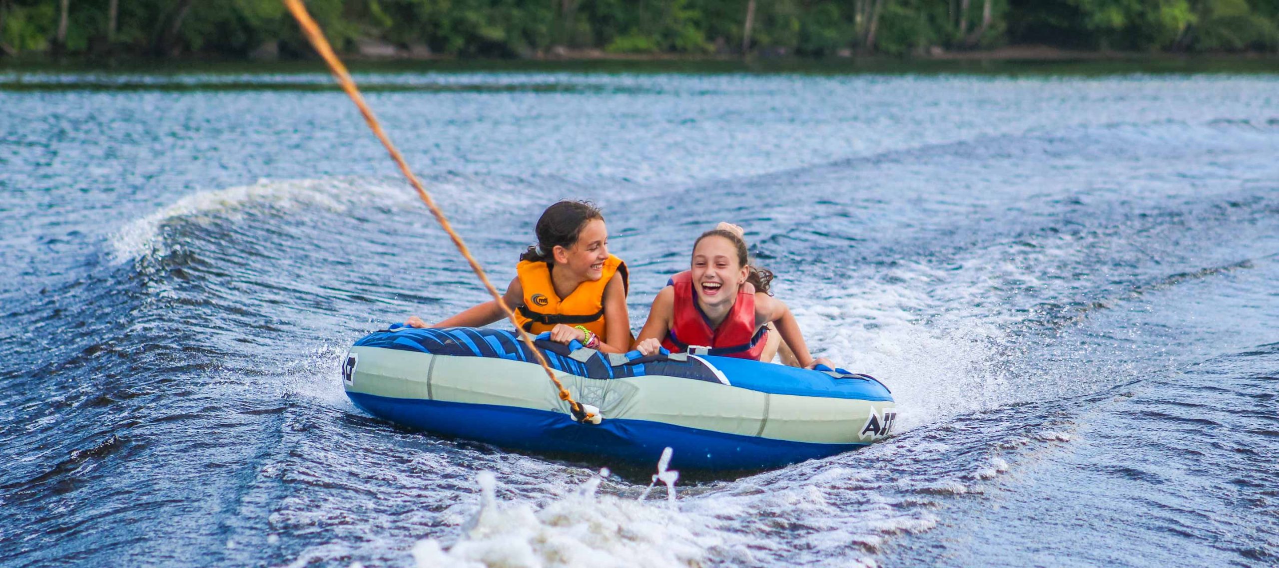 Girls water tubing on lake