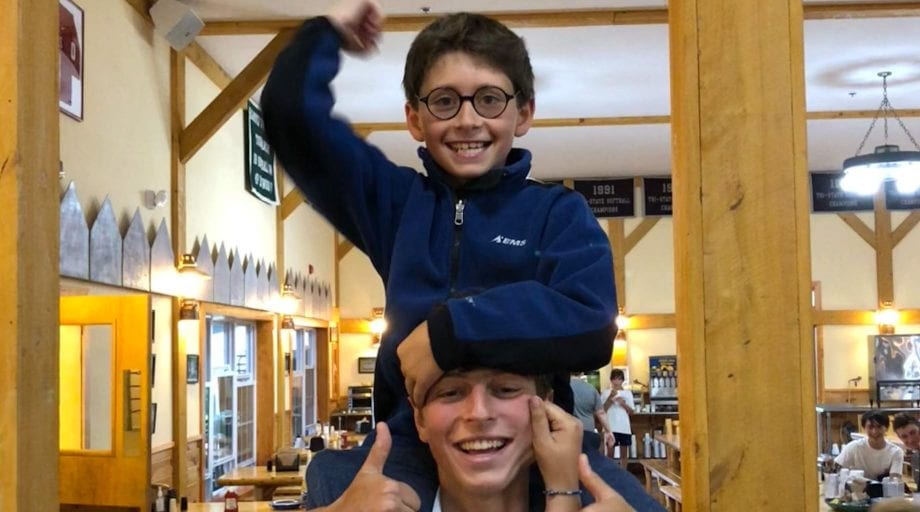 Camper on staff's shoulders in dining hall